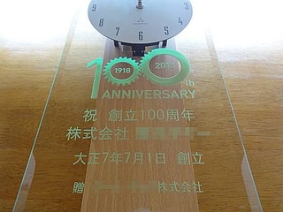 「100th anniversary」「祝創立100周年、株式会社○○、大正○年創立」「贈○○株式会社」と前面ガラスに彫刻した、お取引先へ贈呈する創立100周年祝い用の掛け時計