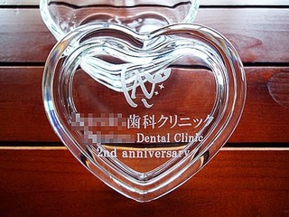 「ロゴマーク」「○○歯科クリニック」「2nd anniversary」を、蓋に彫刻した歯科医院の周年記念品用のガラス製小物入れ