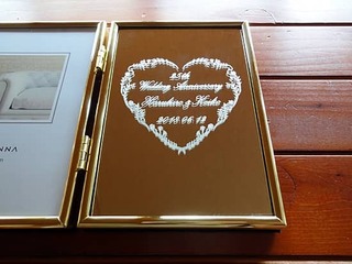 「25th wedding anniversary」「両親の名前」「結婚記念日の日付」「ハートの飾り」を彫刻した、両親の銀婚式の贈り物用の写真立て