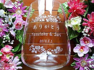 「ありがとう」「新郎と新婦の名前」「結婚式の日付」「バラの花の飾り」を側面に彫刻した、披露宴で新郎と新婦から両親へ贈るプレゼント用のフラワーベース