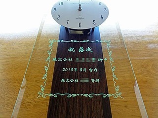 「祝落成、株式会社○○、日付、株式会社○○寄贈」を前面ガラスに彫刻した、お取引先の新社屋の落成祝い用の掛け時計