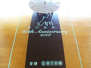 「会社名とマーク、60th anniversary、寄贈 ○○」を彫刻した、お取引先へ贈呈する周年祝い用の掛け時計