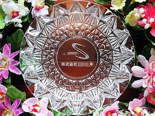 ロゴマークと会社名を底面に彫刻した、お取引先への周年祝い用のガラス製灰皿
