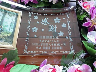 「感謝、○○先生、日付」を彫刻した、卒業生から教授への贈り物用の写真立て