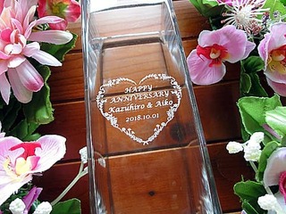 「Happy anniversary、旦那様と奥さまの名前」を彫刻した、結婚記念日のプレゼント用のガラス花器