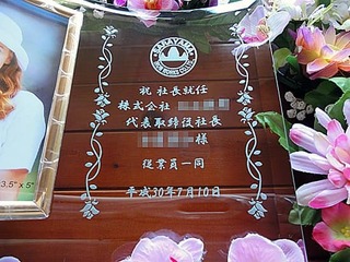「ロゴマークと会社名、祝社長就任 ○○様」を彫刻した、社長就任祝いの贈り物用のガラス製写真立て