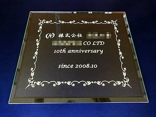 「株式会社○○、10th anniversary」を彫刻した、お取引先への周年祝い用のガラス盾