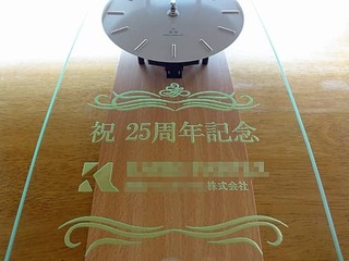 「祝25周年記念」「ロゴマーク」を彫刻した、お得意先の周年祝い用の掛け時計