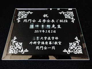 「祝会長就任 ○○先生、日付、○○一同」を彫刻した、会長就任祝い用のガラス盾