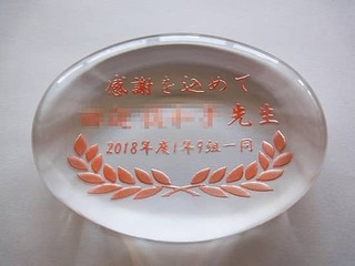 「感謝を込めて ○○先生 ○○一同」を彫刻した、卒業生から担任の先生への贈り物用のペーパーウェイト