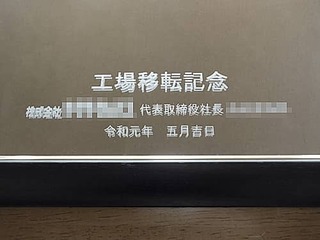 「工場移転記念、株式会社○○代表取締役○○、日付」を彫刻した、お取引先の工場移転祝い用の鏡