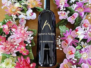 「お店のマーク」と「1st anniversary、日付」を側面に彫刻した、飲食店の周年祝い用のワインボトル