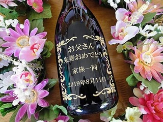 「お父さん 米寿おめでとう、家族一同、日付」を彫刻した、米寿祝い用のワインボトル