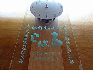 「お店のロゴ」と「祝開店4周年、○○より」を彫刻した、飲食店の周年祝い用の掛け時計