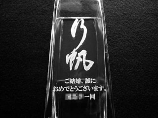 「直筆の名前」と「ご結婚、誠におめでとうございます。○○一同」を彫刻した、職場の同僚への結婚祝い用のガラス花器