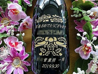 「昇進おめでとうございます、○○様、○○営業所一同」を彫刻した、昇進祝い用のシャンパンボトル