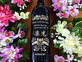 「Happy 60th birthday. All the best for your new life. 」を彫刻した、還暦祝い用のワインボトル
