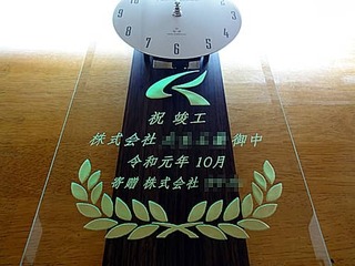 「お取引先のマーク」と「祝竣工、株式会社○○御中、寄贈 株式会社○○」を彫刻した、お取引先への竣工祝い用の掛け時計