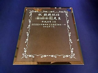「祝教授就任 ○○先生 ○○大学医学部○○教室一同」を彫刻した、教授就任祝い用のガラス盾