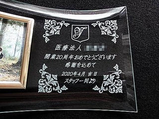 「病院のマーク」と「医療法人○○会 開業20周年おめでとうございます 感謝を込めて 2020年4月吉日 スタッフ一同より」を彫刻した、病院の周年祝い用のガラス製フォトフレーム