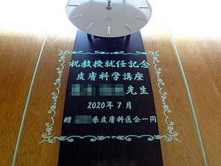 教授就任祝い用の掛け時計(祝教授就任記念 皮膚科学講座 ○○先生 贈○○県皮膚科医会一同を、掛け時計の前面ガラスに彫刻)