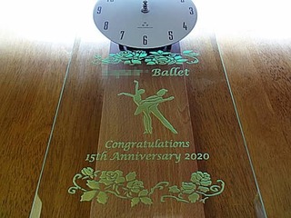 「男女ペアのバレエダンサーのイラスト」と、「○○Ballet Congratulations 15th anniversary」を彫刻した、バレエ教室の周年祝い用の掛け時計