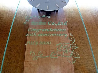 「○○ Co., Ltd. Congratulations! 20th anniversary」を前面ガラスに彫刻した周年祝い用の掛け時計