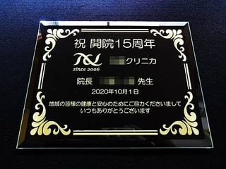 「ロゴマーク」と「祝開院15周年 ○○クリニカ 2020年10月1日」を彫刻した、診療所の周年祝い用のガラス盾