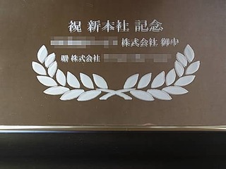 「祝新本社記念 ○○株式会社御中 贈株式会社○○」を彫刻した、新社屋落成祝い用の鏡