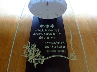 「祝古希 お誕生日おめでとう これからも健康第一で楽しい日々を いつもありがとう」を前面ガラスに彫刻した、古希祝い用の掛け時計