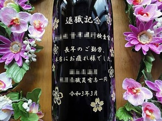 「退職記念 ○○様 長年のご勤労本当にお疲れさまでした ○○一同」をボトル側面に彫刻した、定年退職祝いの贈り物用のお酒