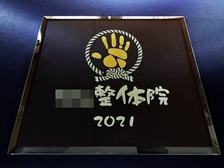 「整体院のロゴマークと2021」を彫刻した、整体院の開業祝い用のガラス盾