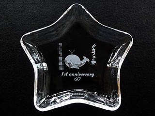 「カフェのロゴマークと1st anniversary」を中央に彫刻した、カフェの周年祝い用のガラス製小物入れ