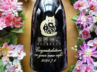 「カフェのロゴマーク、Congratulations on your new cafe! 」をボトル側面に彫刻した、カフェの開店祝い用のシャンパン