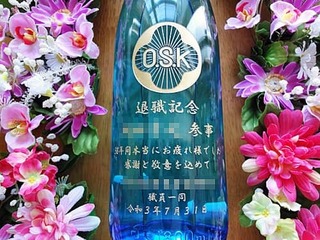「組合のマークと、退職記念 ○○参事 感謝と敬意を込めて ○○組合職員一同」をボトル側面に彫刻した、定年退職祝い用のお酒