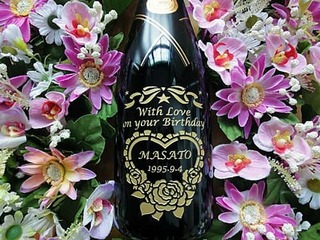 「With Love on your birthday、贈る相手の名前、誕生日の日付」をボトル側面に彫刻した、誕生日プレゼント用の名入れボトル(シャンパン)