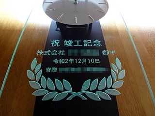 「祝竣工記念 株式会社○○御中、竣工式の日付、贈り主の名前」を前面ガラスに彫刻した、新社屋の竣工祝い用の掛け時計