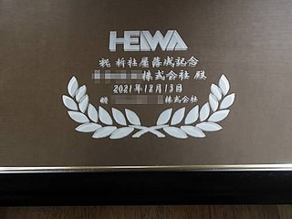 「贈り先の会社のロゴ」と「祝新社屋落成記念 ○○株式会社御中 2021年12月13日 贈○○株式会社」を彫刻した、新社屋の落成記念用の鏡