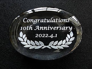 「Congratulations 10th Anniversary、表彰日の日付」を彫刻した、勤続10年表彰の記念品用のペーパーウェイト