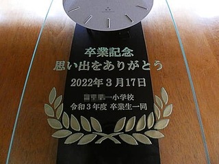 「卒業記念 思い出をありがとう ○○小学校令和3年度卒業生一同」を前面ガラスに彫刻した、卒業生から小学校へ寄贈する卒業記念品用の掛け時計