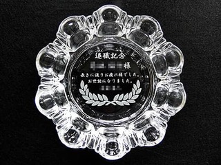 「退職記念 ○○様 長きに渡りお疲れさまでした」を底面に彫刻した、定年退職祝い用のガラス製灰皿