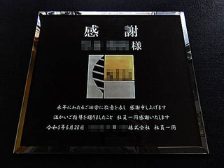 「感謝を込めたメッセージ、定年退職する方の名前、会社のロゴマーク、退職日の日付、会社名」を彫刻した、定年退職のお祝い用のガラス盾