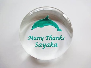 「イルカのイラスト、Many Thanks、退職する方の名前」を彫刻した、定年退職の記念品用のガラス製ペーパーウェイト