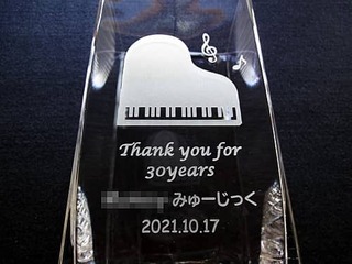 「ピアノのイラストと、Thank you for 30years ○○みゅーじっく 日付」を側面に彫刻した、音楽教室の周年祝い用のガラス花瓶