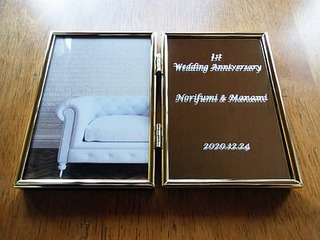 1st wedding anniversary、旦那様と奥様の名前、結婚記念日の日付を彫刻した、結婚1周年祝い用のブック型写真立て