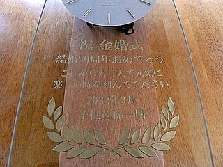 「祝金婚式 結婚50周年おめでとう これからも二人で元気に楽しい時を刻んでください」を前面ガラスに彫刻した、両親の金婚式祝い用の掛け時計