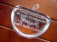 「Congratulations on your graduation、卒業生の名前」を側面に彫刻した、卒業記念品用のガラスのオブジェ