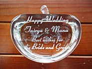 「Best wishes for the bride and groom、新郎と新婦の名前」を側面に彫刻した、結婚祝い用のガラスのオブジェ