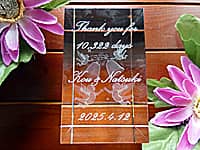 生まれてから結婚式まで日数、新郎と新婦の名前、結婚式の日付を側面に彫刻した、新郎新婦から両親へのプレゼント用のガラスのオブジェ