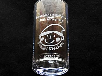 飲食店のロゴマークを側面に彫刻した、飲食店の周年祝い用のフラワーベース